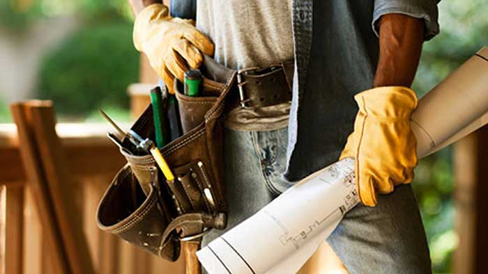 Construction Worker with toolbelt and holding blueprints